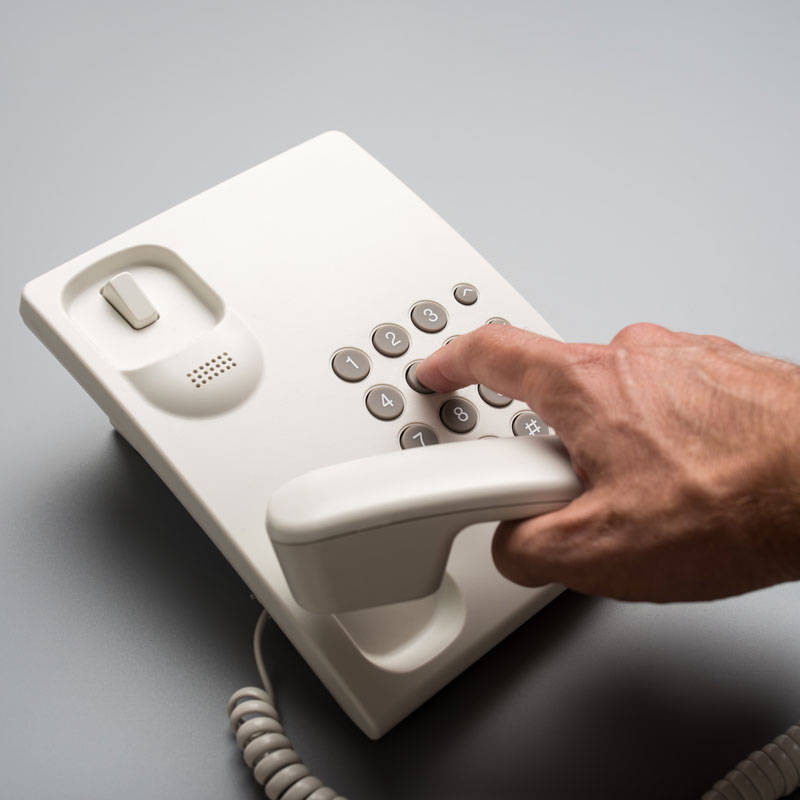 Male Hand Dialing a Telephone number from an analog phone